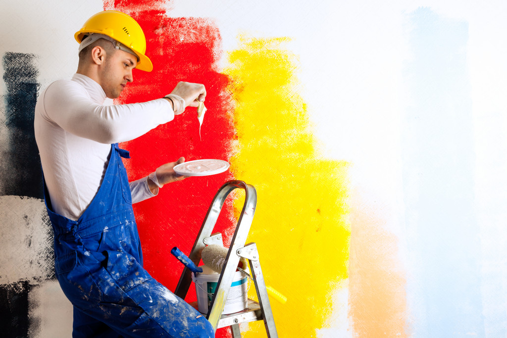 painter in the ladder testing paint