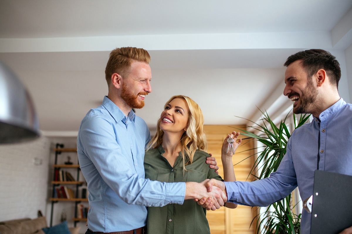 an agent handing house keys to a couple