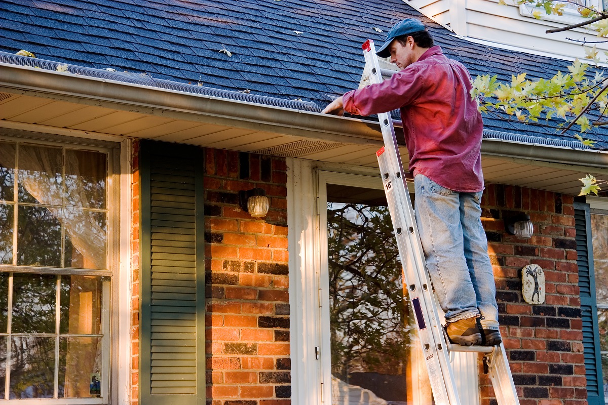 man cleaning gutters