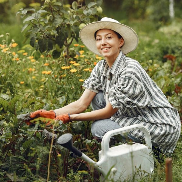 Woman watering flowers with a watering can.